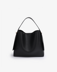Remi and Reid Paloma Shoulder Bag in textured black vegan leather, featuring a unique wing-like silhouette with a flat top handle.