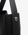 Details of Remi and Reid Paloma Shoulder Bag in textured black vegan leather, featuring a unique wing-like silhouette with a flat top handle.