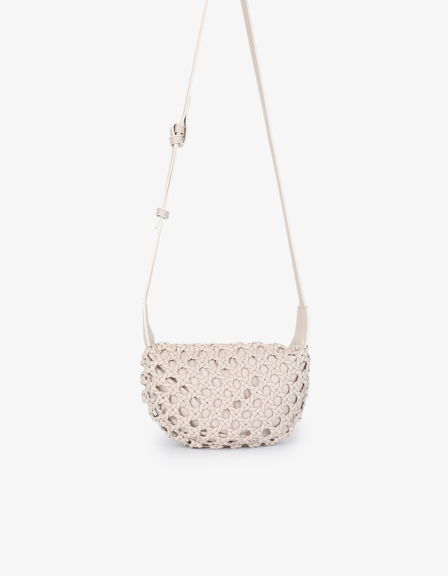 Small woven cream-colored crossbody bag with adjustable strap by Remi and Reid