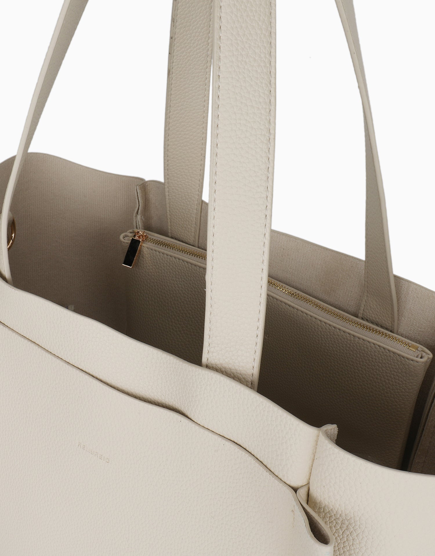 Close-up of a beige handbag with handles and interior details_Remi and Reid
