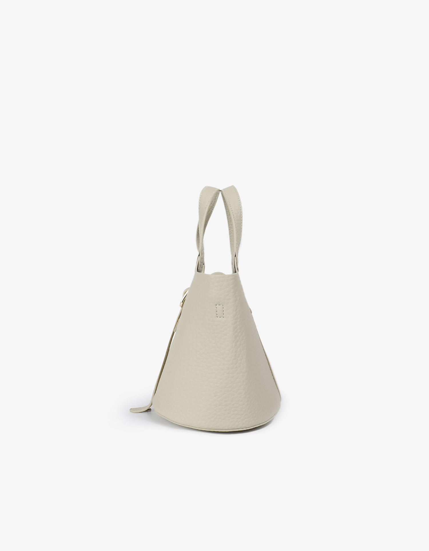 Cream vegan leather bucket bag shown from a side angle to highlight the pebbled texture and shape by Remi and Reid.