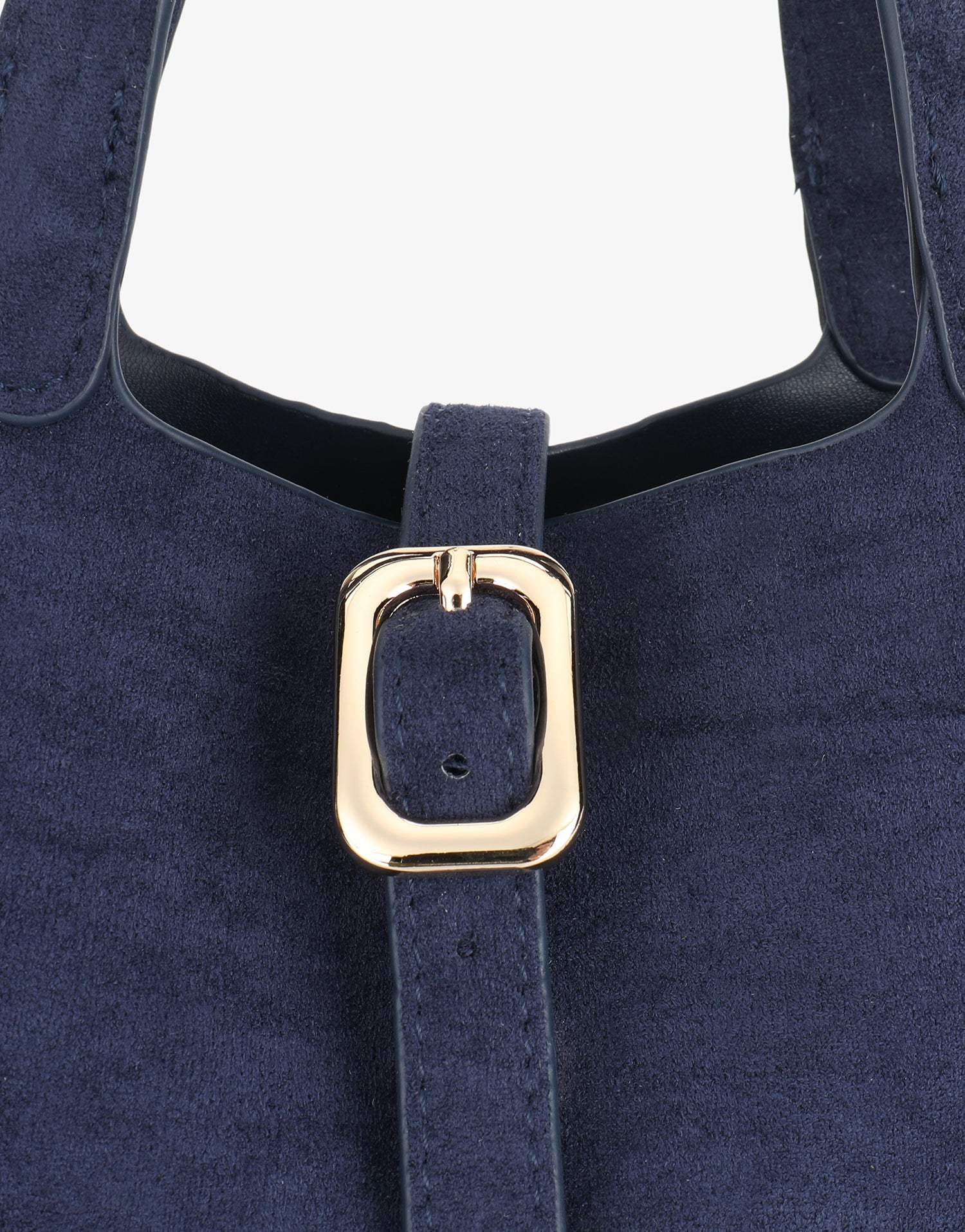 Navy blue faux suede handbag with a gold buckle in close-up_Remi and Reid