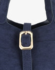 Navy blue faux suede handbag with a gold buckle in close-up_Remi and Reid