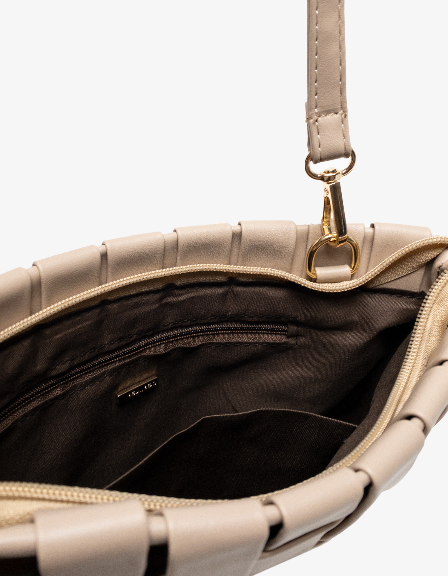 Close-up of Light tan handbag with gold clasp by Remi and Reid with zippered and slip pockets.