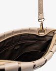 Close-up of Light tan handbag with gold clasp by Remi and Reid with zippered and slip pockets.