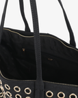Close-up of the Oya Grommet Canvas Tote in black with gold eyelets and a zippered interior pocket by Remi and Reid.
