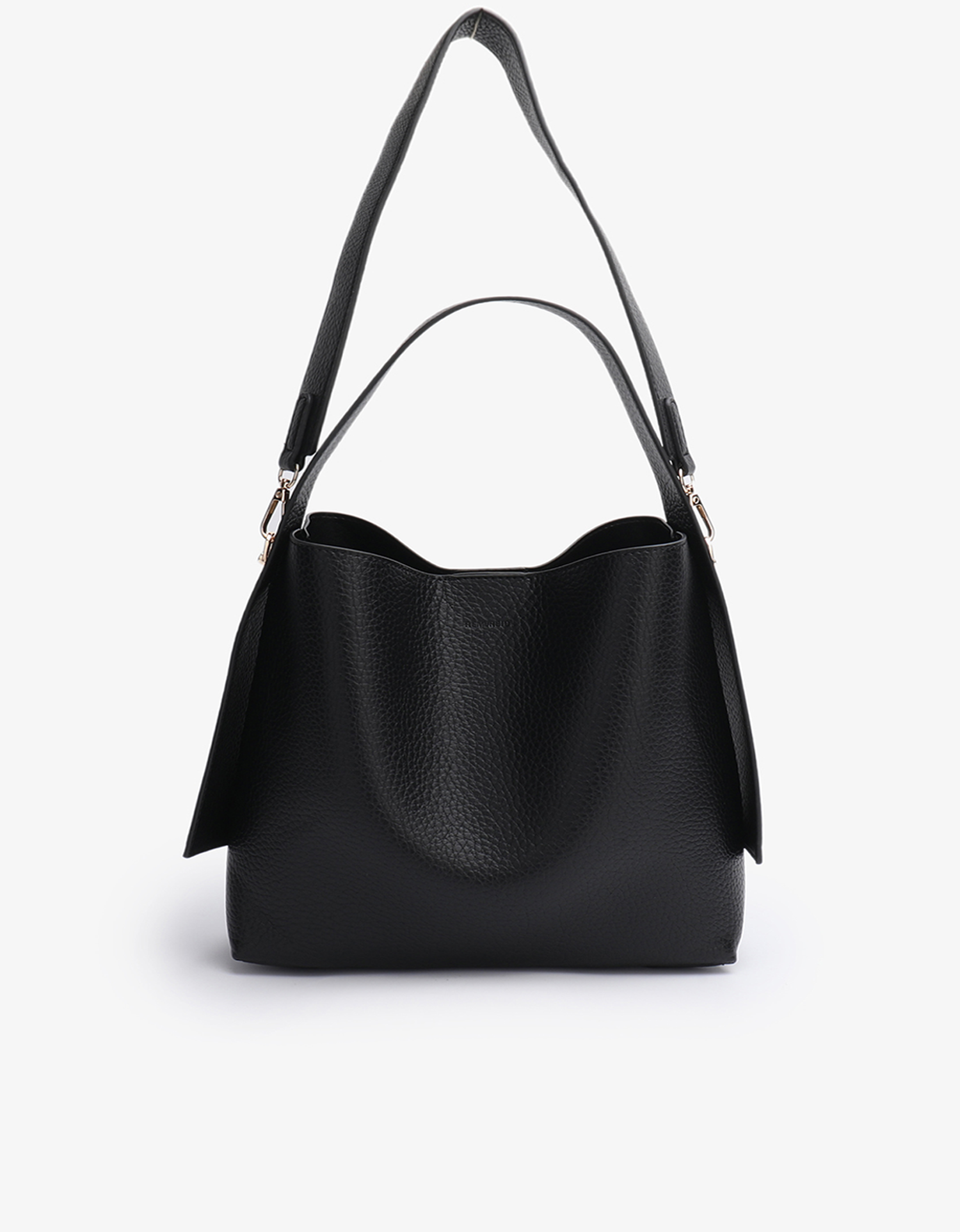 Remi and Reid Paloma Shoulder Bag in textured black vegan leather, featuring a unique wing-like silhouette with a flat top handle and a removable, adjustable shoulder strap.