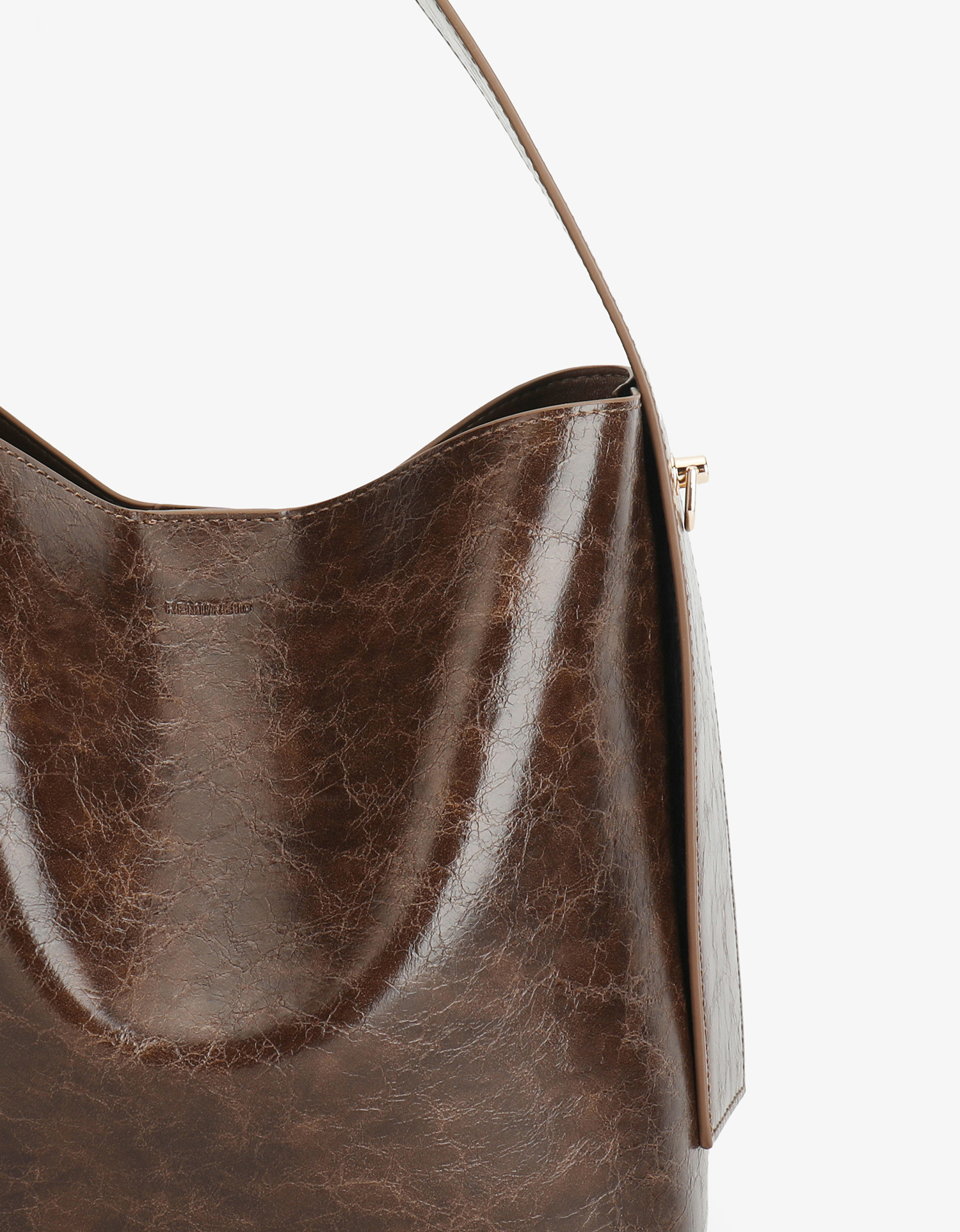 Close-up of Paloma Waxed vegan leather shoulder bag in brown espresso featuring a wide single strap handle and gold-tone buckle hardware on the side.