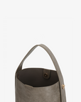 Paloma Waxed vegan leather shoulder bag in gray featuring a wide single strap handle and gold-tone buckle hardware with magnetic snap closure inside by Remi and Reid.