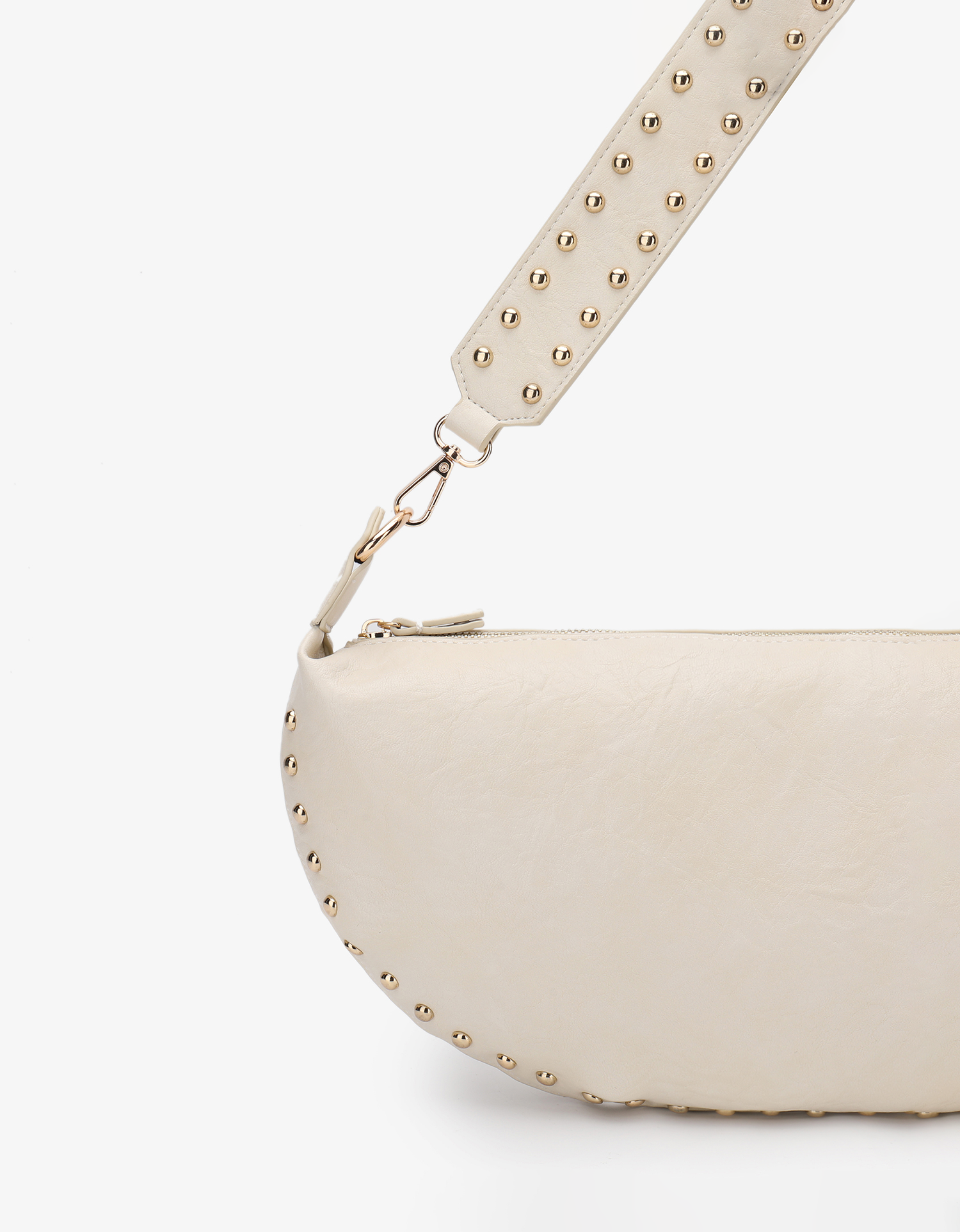 Crescent-shaped shoulder bag featuring gold-tone studs on the seam with studded shoulder strap by Remi and Reid.