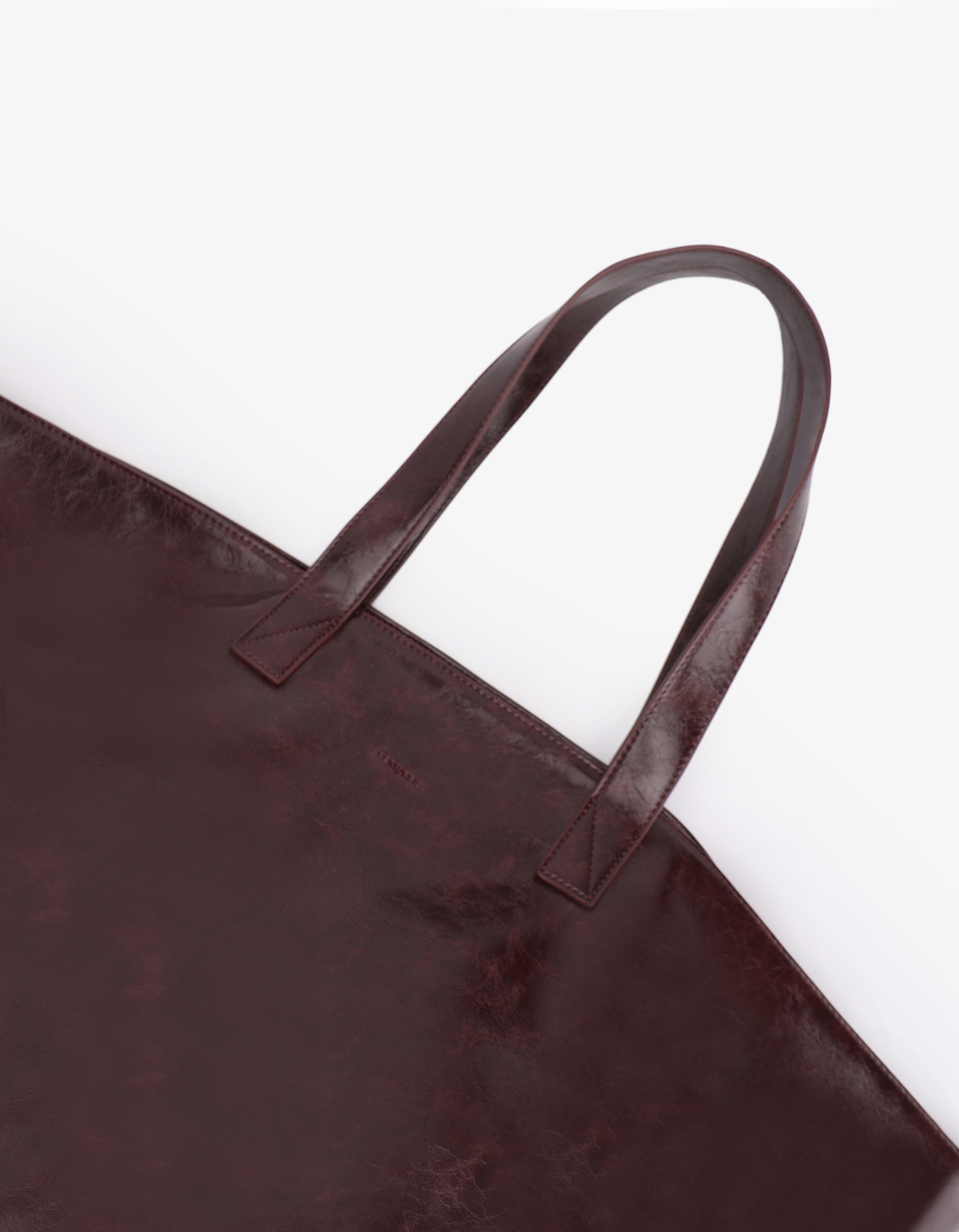 Extra Large Plaisir Tote by Remi and Reid in a deep oxblood red waxed vegan leather with a high-shine, crinkled texture.