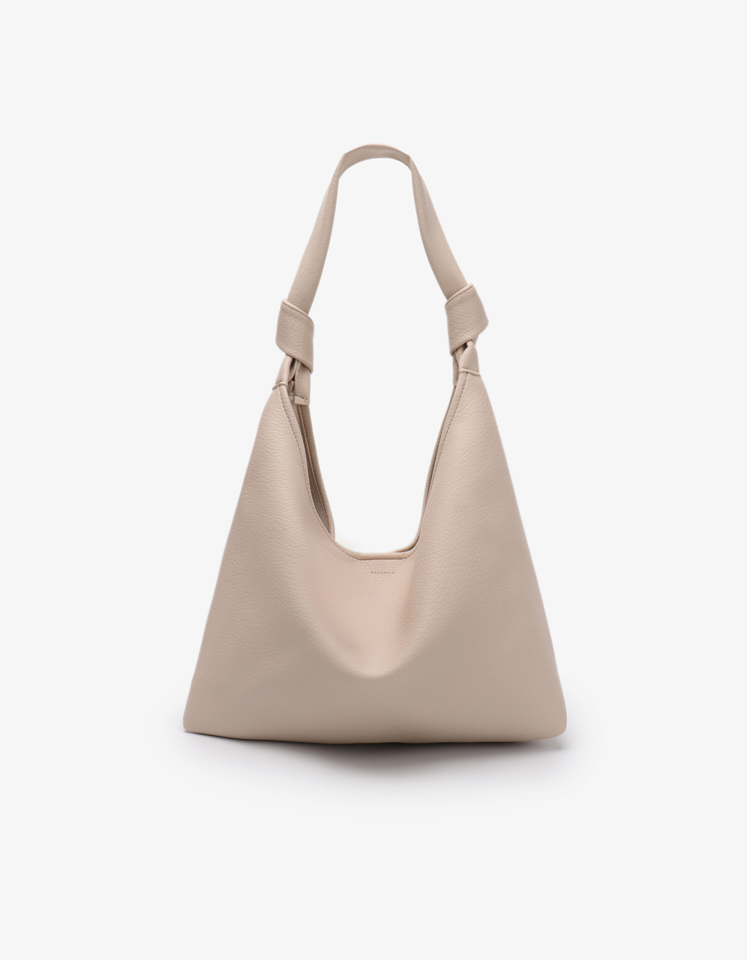 A beige shoulder bag with a knotted strap and a minimalistic design by Remi and Reid.